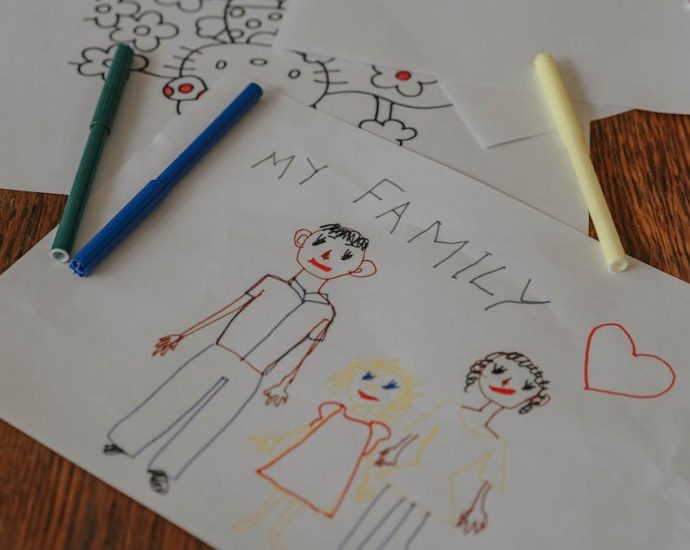 A hand-drawn family portrait using colored markers on paper, showcasing creativity and love.